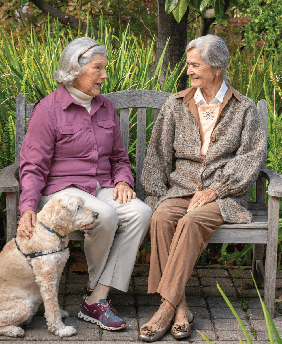 seniors sitting on bench with dog