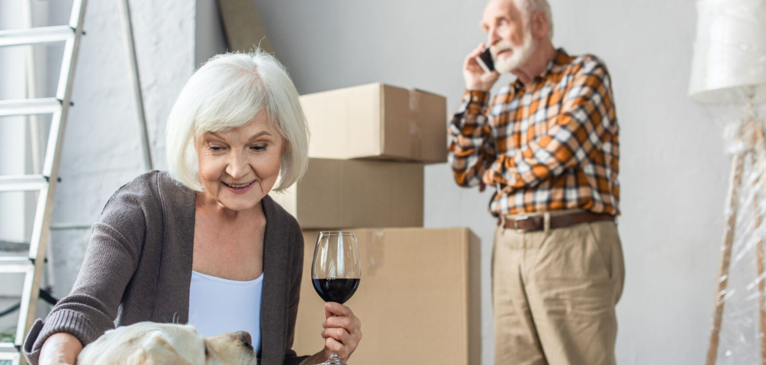 seniors boxing up their home and having wine